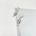 Women's fishbone pendant necklace and matching earrings set with adjustable chain on retro background