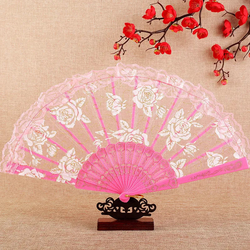 Plastic rose lace folding fan in red with tassel on white background