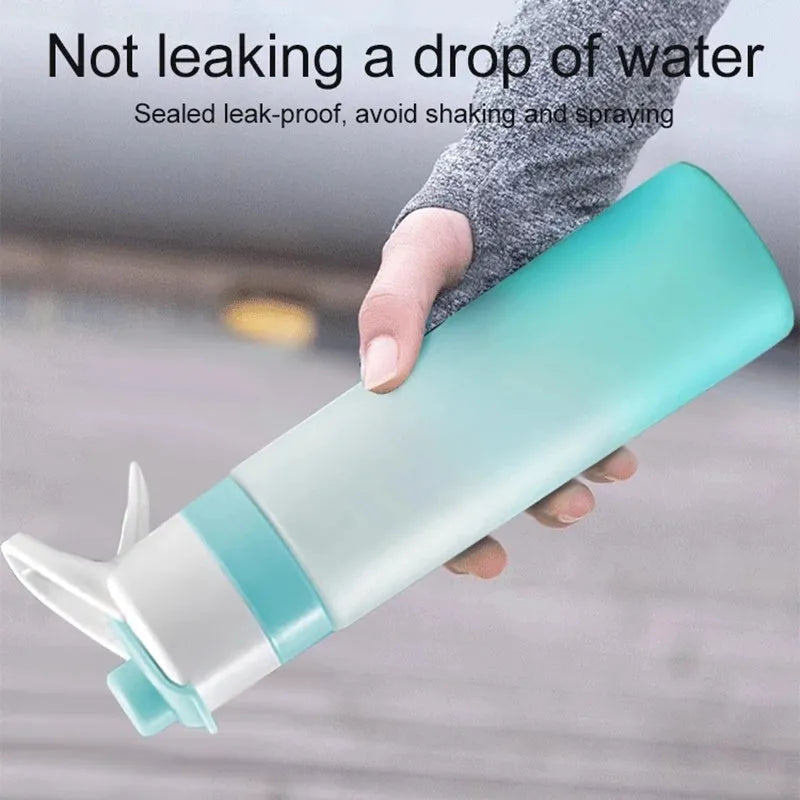 Large pink plastic spray water bottle with a handle strap and leakproof lid on a gym bag.