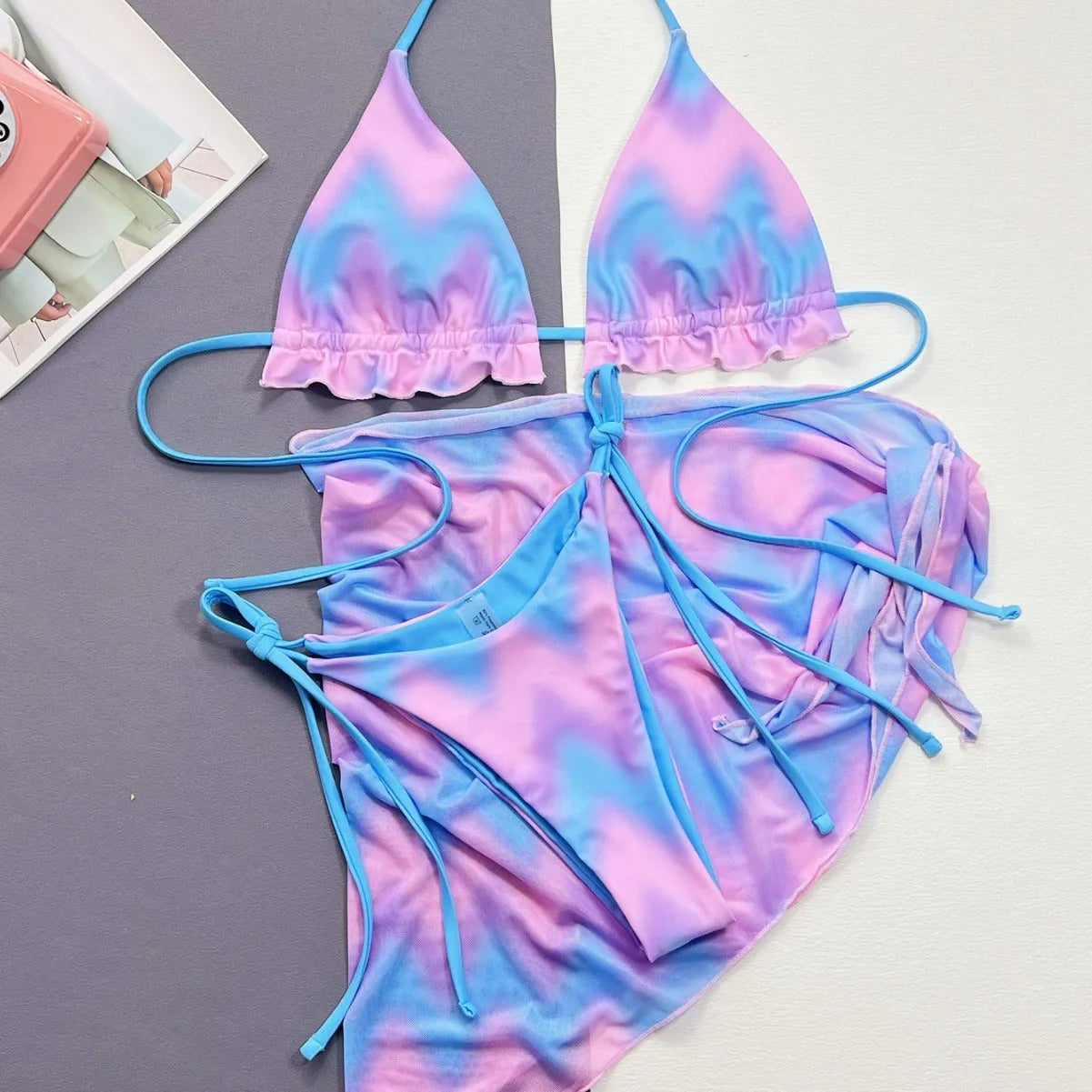 Women's tie-dye bikini swimsuit set with a skirt, bra, and matching briefs.