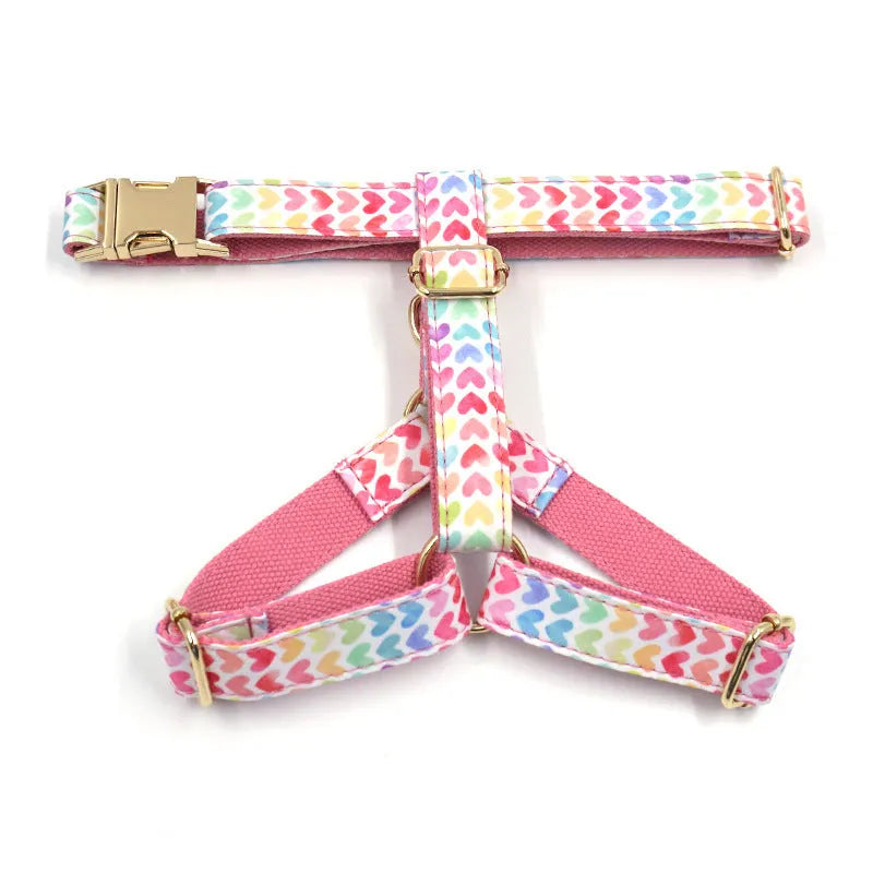 Pink dog harness with a gold buckle and a colourful heart-shaped stone on the chest strap.