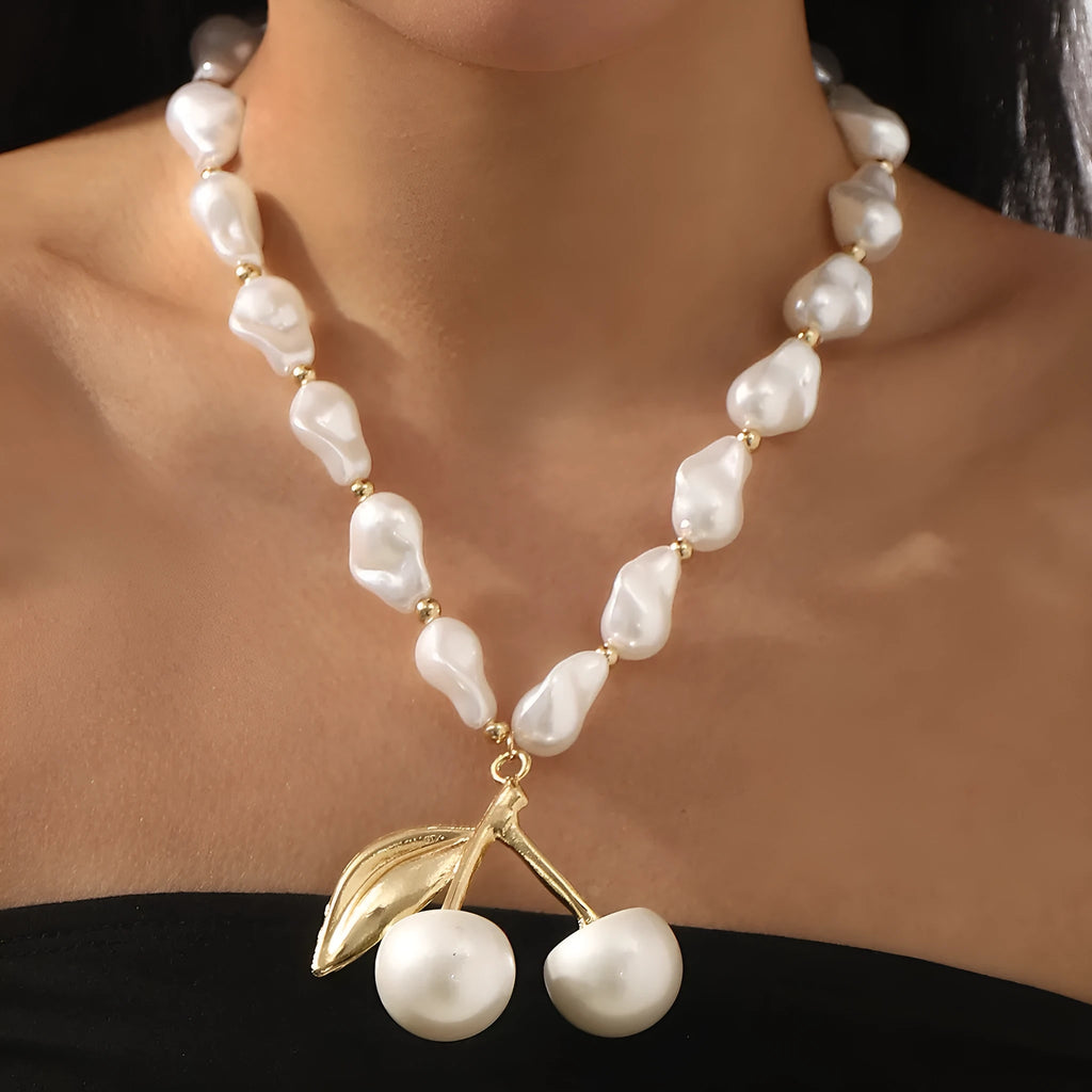 Gold-coloured adjustable necklace with a fruit-shaped pendant on a pearl-style chain.