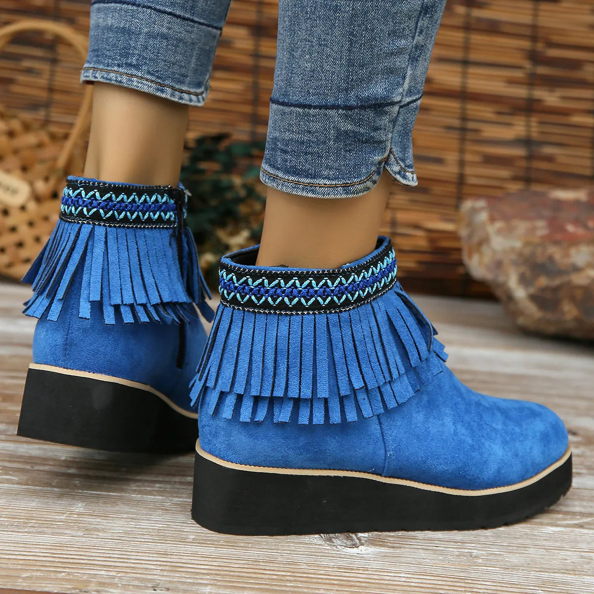Women's black suede wedge ankle boots with a side zip and tassel detail on a thick rubber sole.