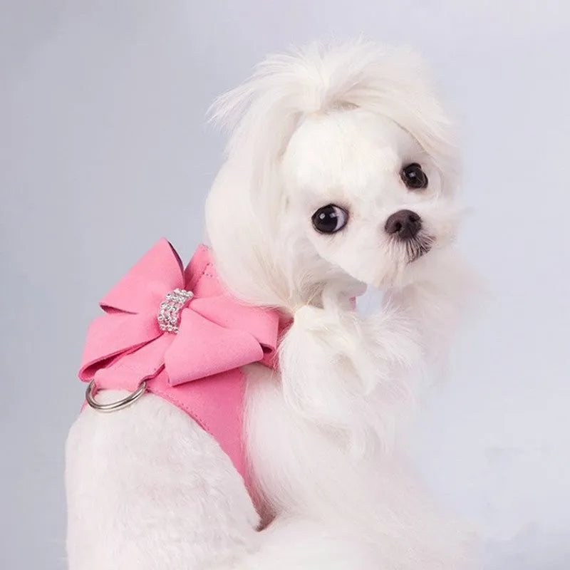 Pink adjustable dog chest strap with a cute bowknot detail, shown on a small puppy.