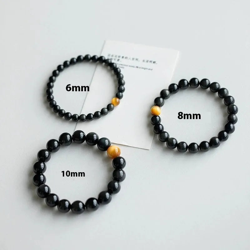 Natural black obsidian geometric bead bracelet on an adjustable string, showing 10mm bead size.