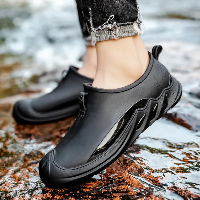 Men's short black plastic rain boots shown in a casual setting