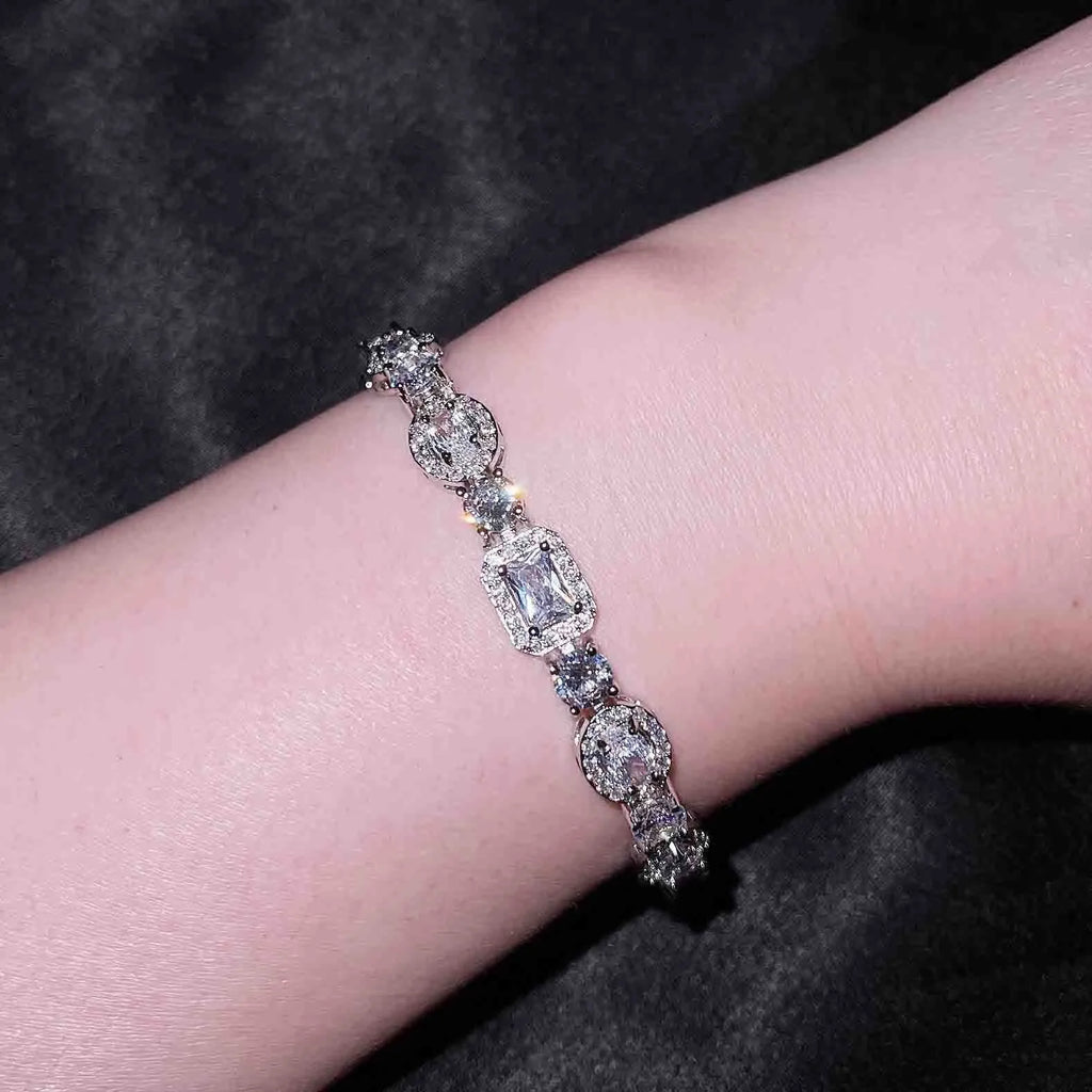 Women's geometric silver-plated bracelet with inlaid zircon stones on a wrist.