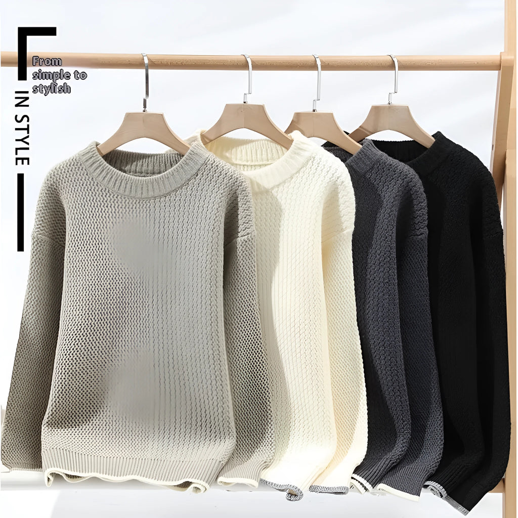 Man wearing a grey loose fit round neck long sleeve pullover sweater