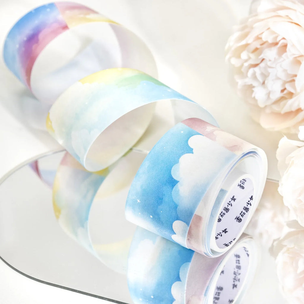 Roll of Japanese paper sky theme washi tape showing colourful clouds design, 30mm wide.