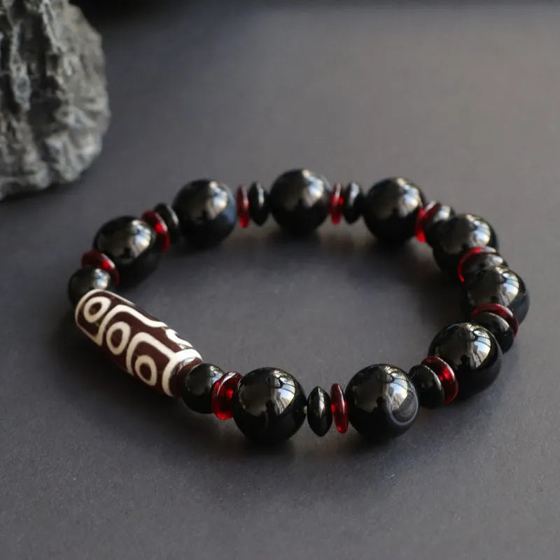 Hand-woven black agate dzi bead bracelet with 11mm geometry beads on a wrist.