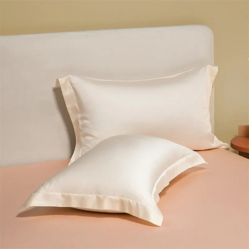 A modern Lenzing Tencel bedding set with a quilt cover and pillowcases in a neutral colour, laid flat on a bed.