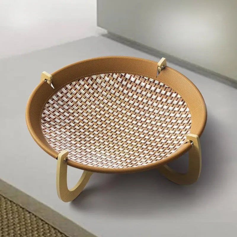 Brown woven rattan raised cot bed for cats and small dogs on a wooden floor