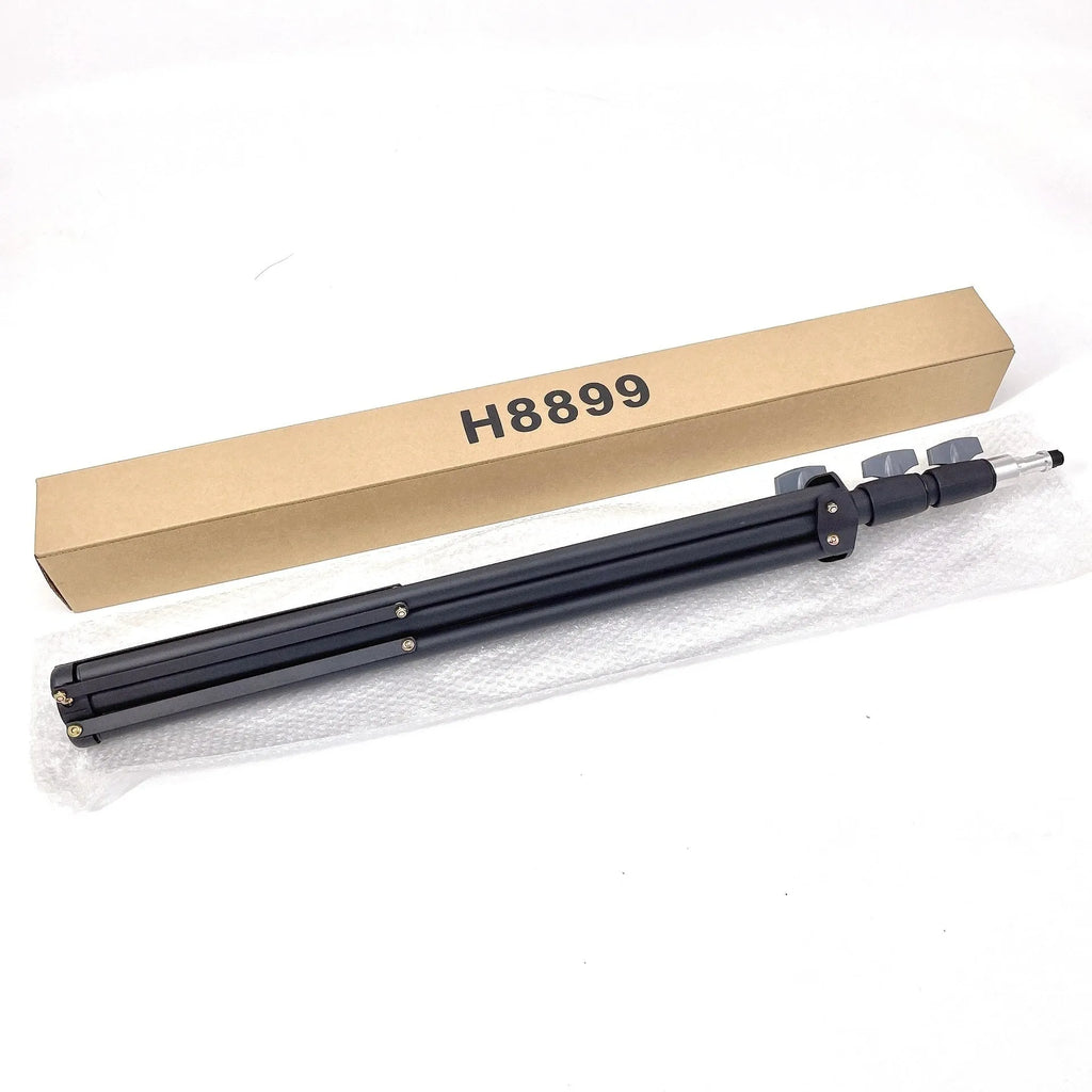 Black mobile phone tripod extended to 1.1m on a desk showing metal legs and phone mount