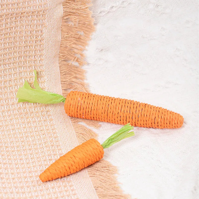 Set of assorted cat toys including fabric carrots, plastic ringing stones, paper crinkles, and wooden grinding sticks