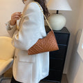 A women's black pleated chain baguette shoulder bag with a vertical square shape and an adjustable strap.