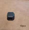 White and black magnetic under-desk cable clips organising various cables with adhesive backing