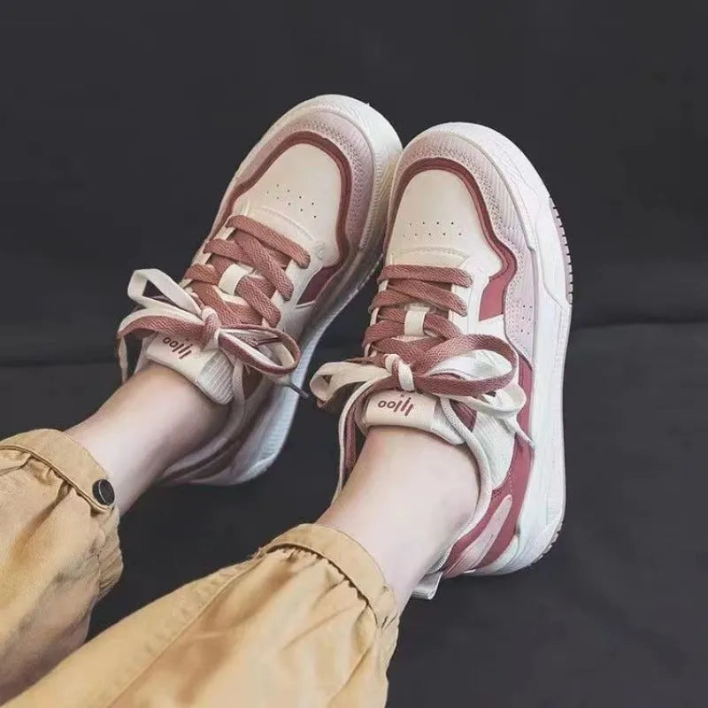 Women's pink low-top sneaker with imitation leather upper and rubber sole on a plain background.