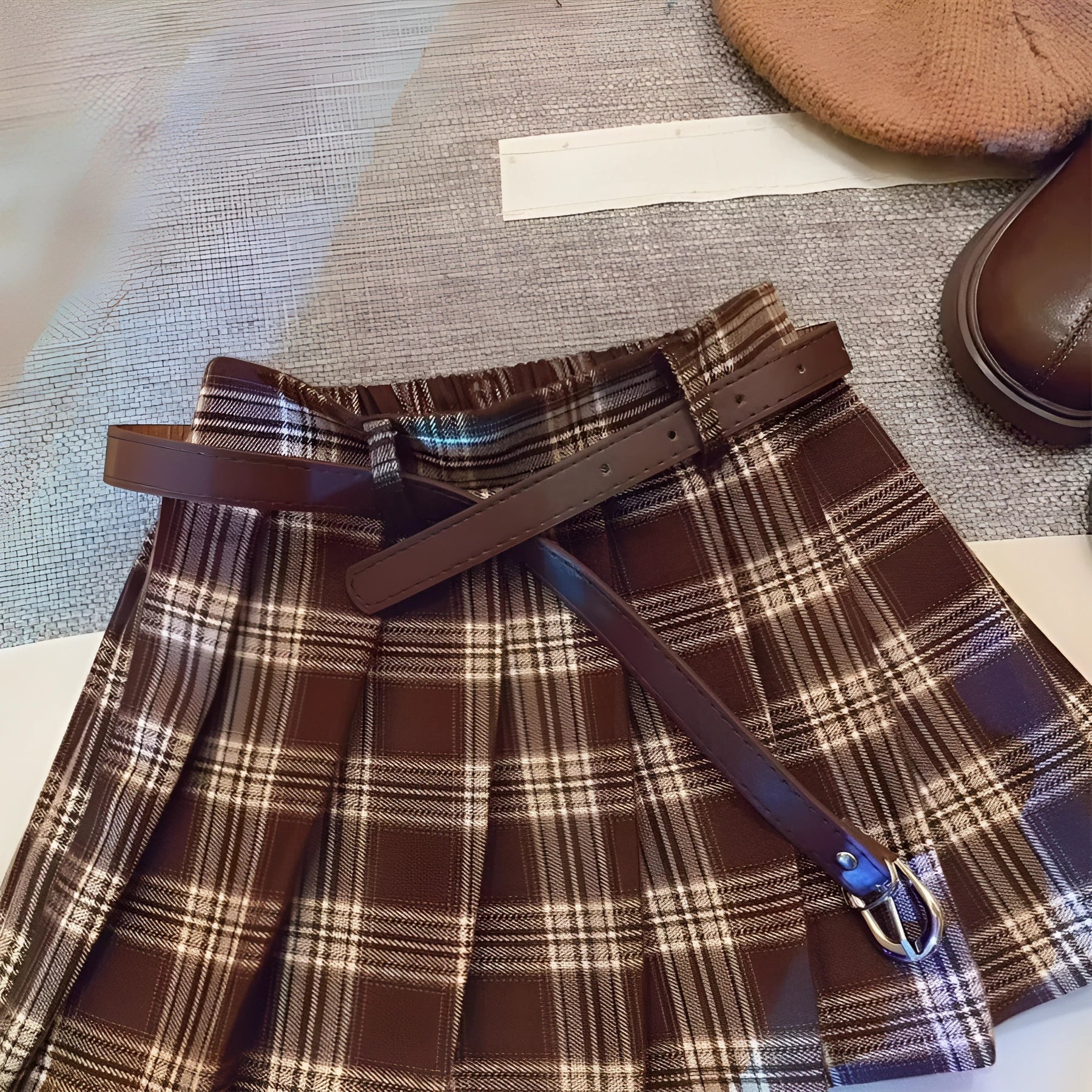 Girls' plaid pleated A-line skirt in a cotton blend fabric, shown on a hanger.