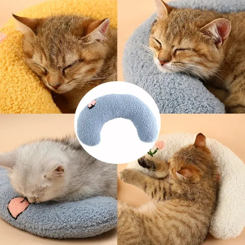 Small white half-donut U-shaped plush pillow for a cat or small dog on a carpet