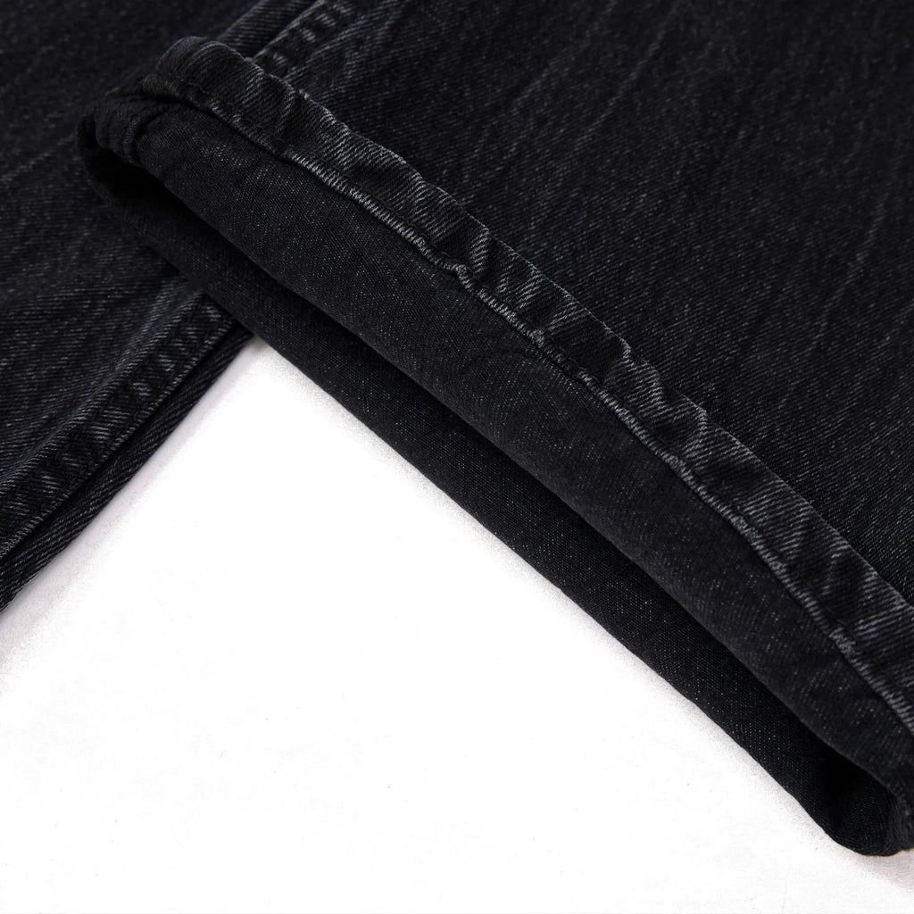 Black straight-leg men's jeans with a distressed lightning crack pattern on the legs.