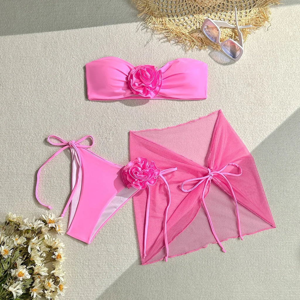 Women's pink bikini set with large 3D flower tie on tube top, matching skirt and pants.