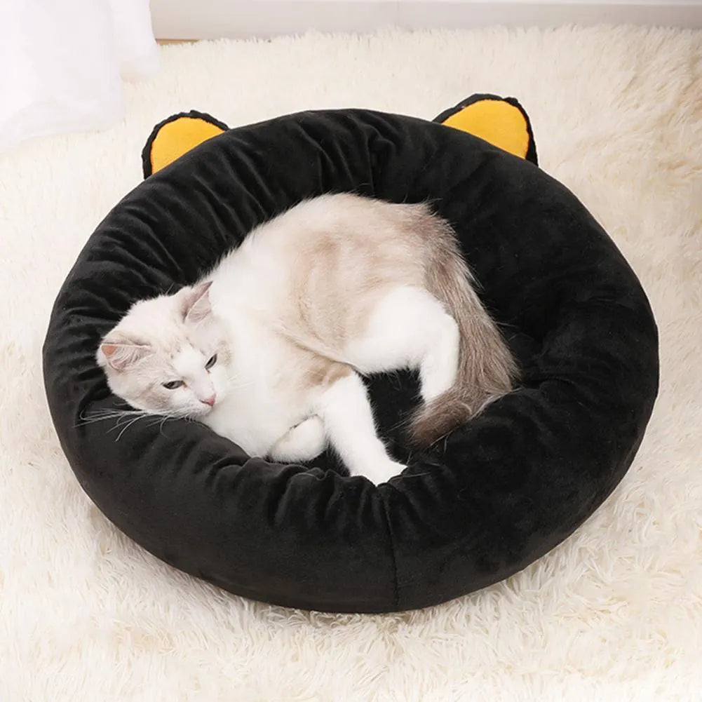Black cat shaped velvet pet bed with raised edges for feline head and neck support
