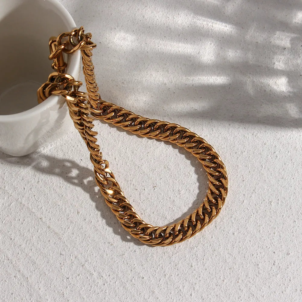 Stainless steel 18K plated gold clavicle necklace with thick encrypted chain and OT buckle on white background