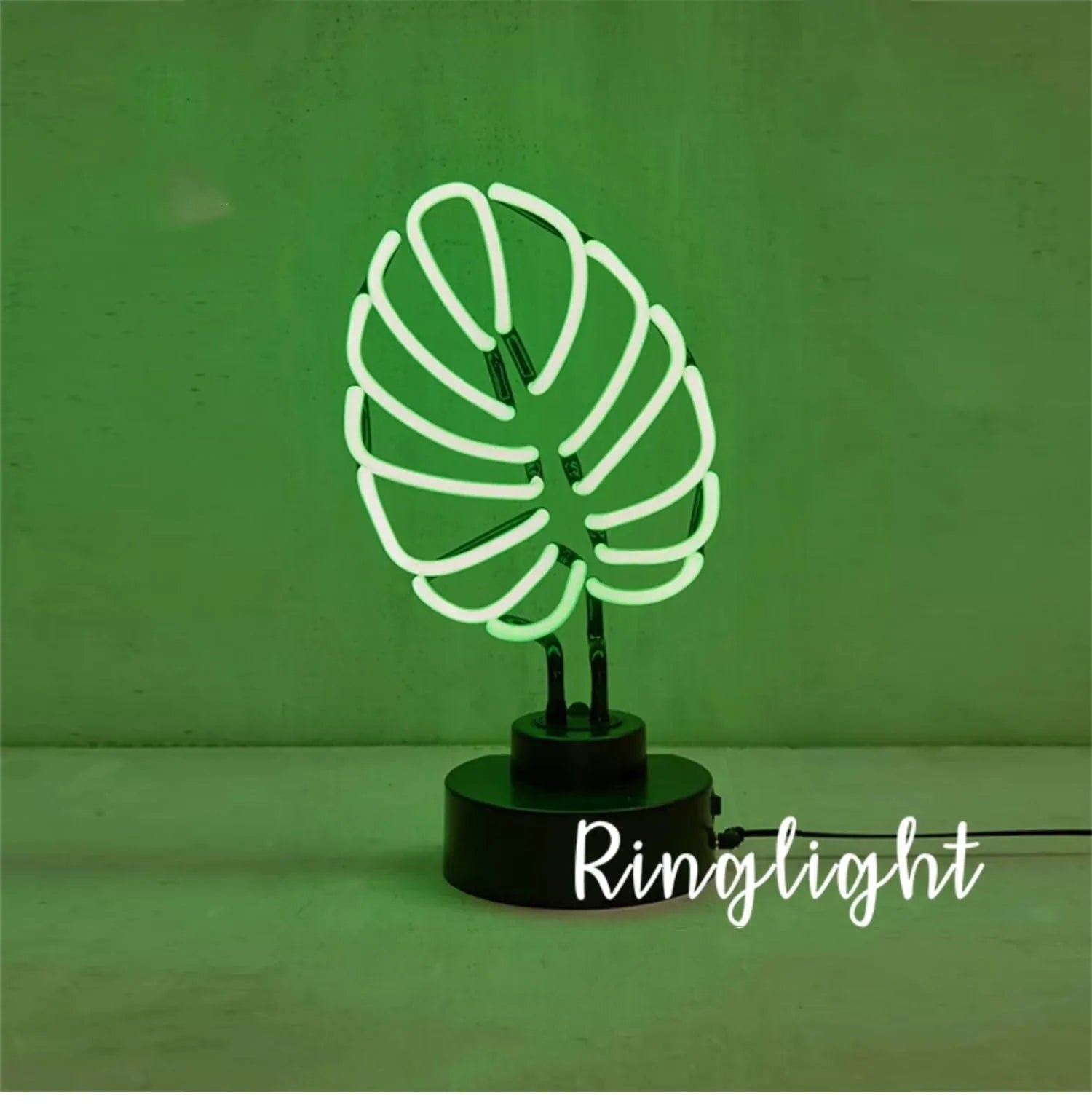 Minimalist white bamboo-shaped desk lamp emitting a soft green light, shown on a table.