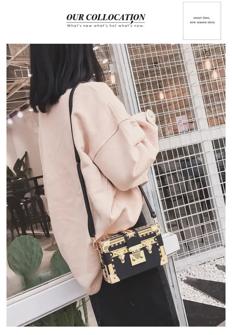 Black structured women's shoulder bag with flap and single strap.