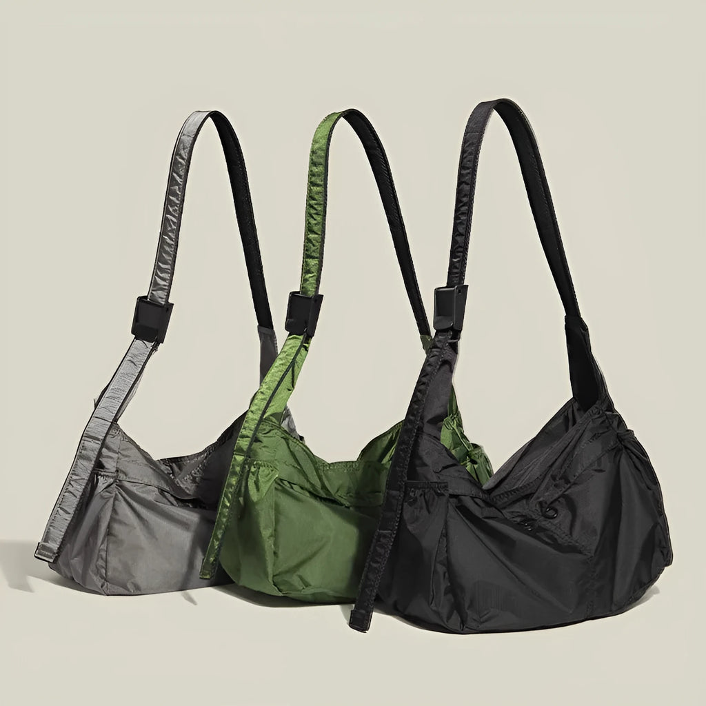 Casual black waterproof nylon messenger bag with single shoulder strap showing interior phone compartment