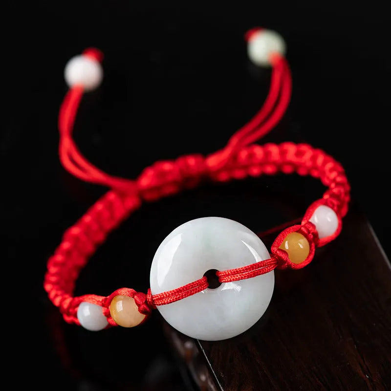 Round emerald jade pendant on adjustable red cord bracelet