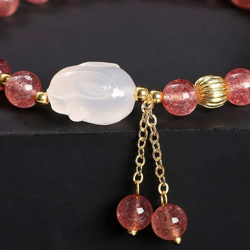 Women's white rabbit bracelet with 6mm round strawberry quartz agate beads in a geometric pattern.