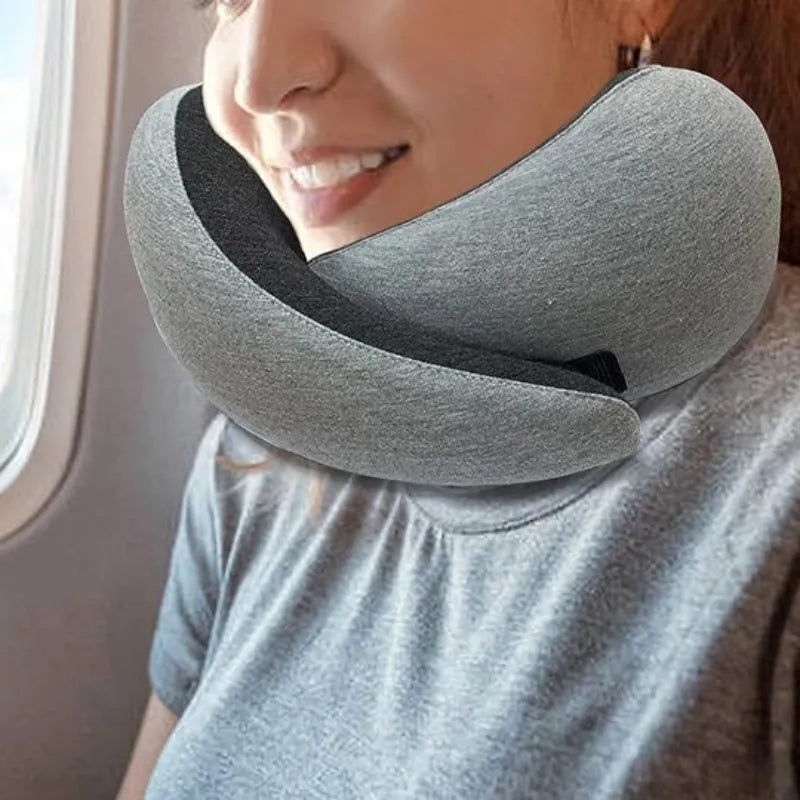 Navy blue U-shaped travel neck pillow with memory foam, shown rolled up next to its carry bag.