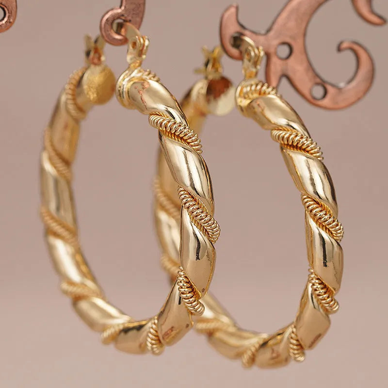 Geometric women's earrings made of copper in a gold finish, featuring a ring and line design.