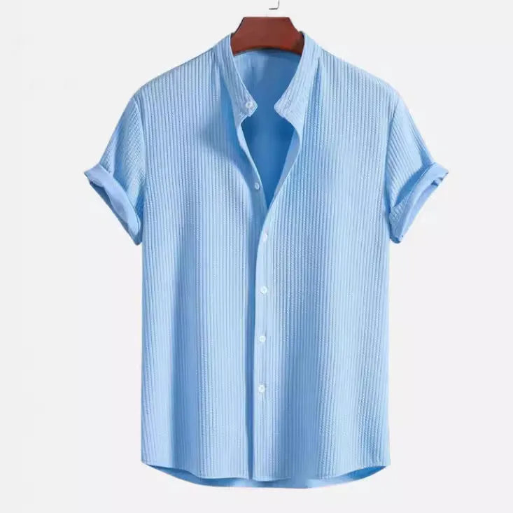 Man wearing a loose fit short sleeve polyester summer shirt in a light blue colour.