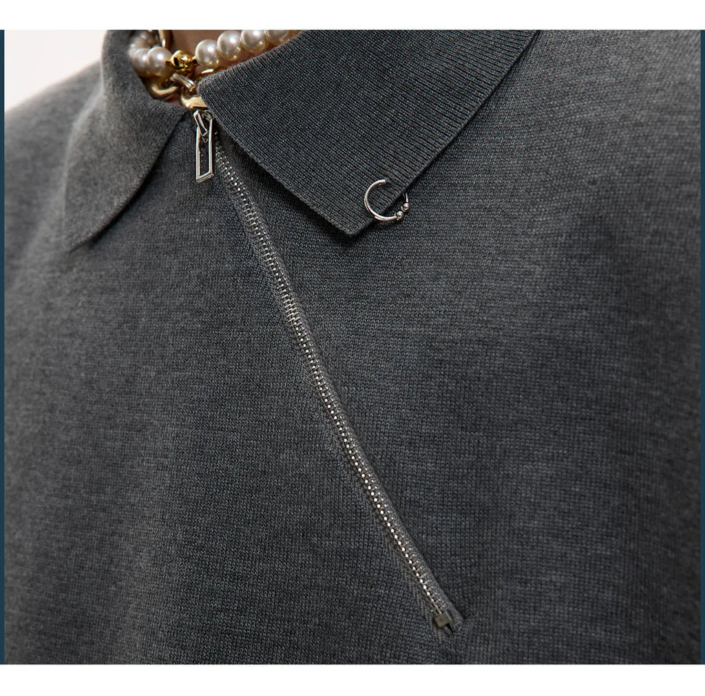 Man modelling a black slim-fit knitted polo shirt with a diagonal chest zipper and lapel collar.