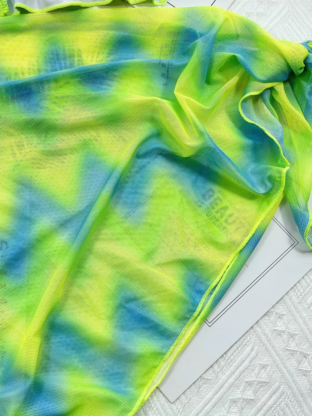 Green tie-dyed women's bikini set with sleeveless top, briefs, and a matching outer skirt.