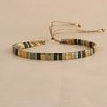 Geometric glass beaded bracelet in milky white, black, green, blue, or red on a plain background.