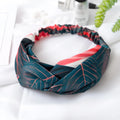 Red cloth headband with banana leaf pattern, showing wide band and elastic back.
