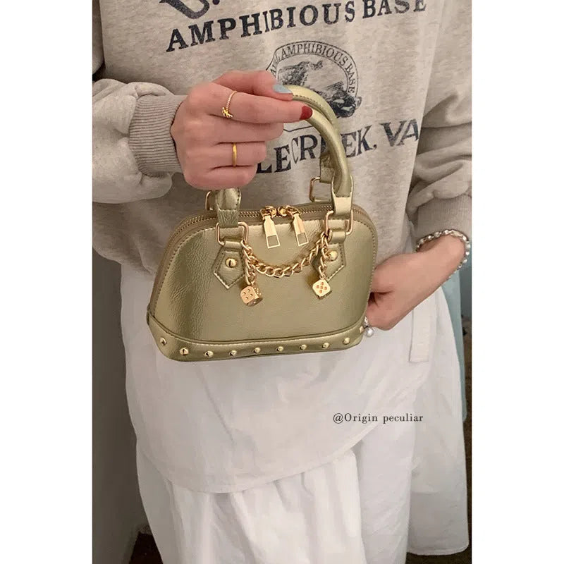 Champagne-gold PU shell bag with stitched seams, worn as a shoulder bag against a neutral background