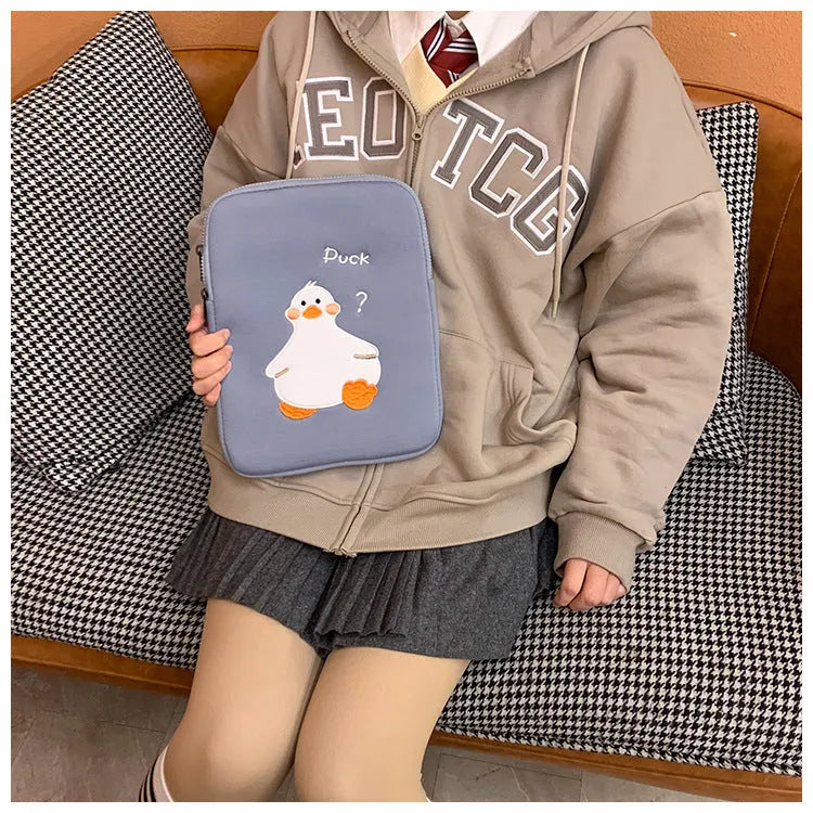 Blue cotton tablet case with cartoon duck embroidery and a zipper, shown next to a green version.