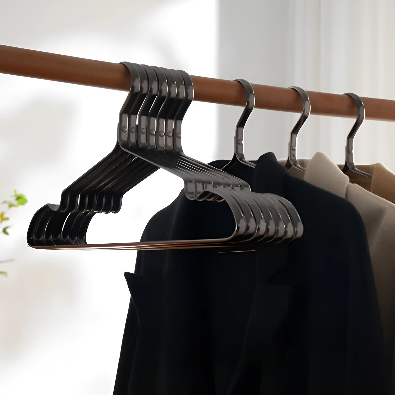Modern elegant black clothes hanger with non-slip surface on a white background.