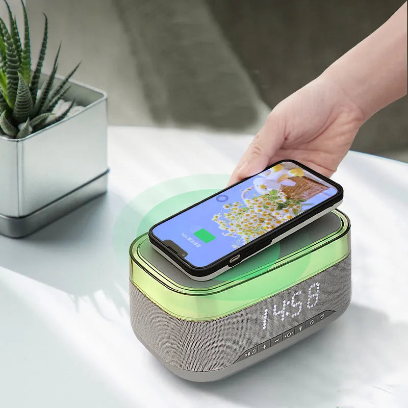 White multifunctional alarm clock unit with Bluetooth speaker and wireless charging pad.