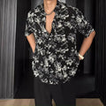 Black and white loose-fit floral printed short sleeve casual shirt on a hanger.