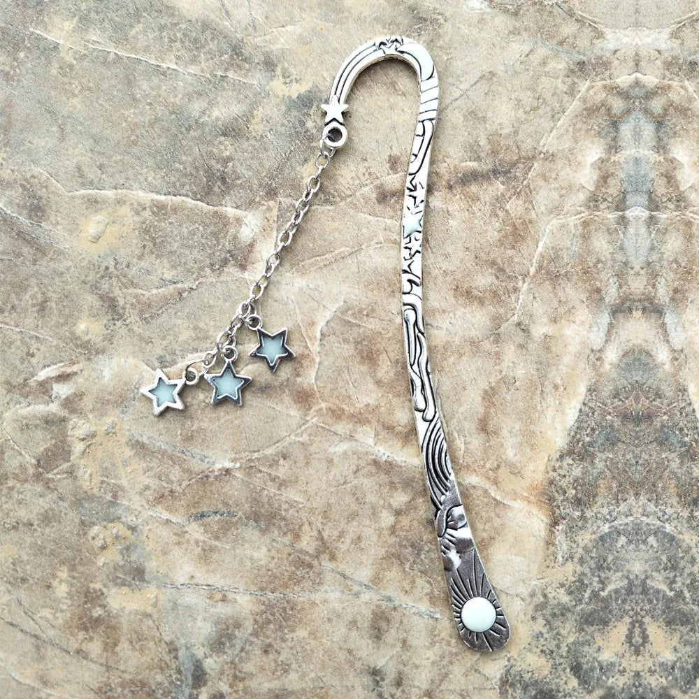 Retro five-pointed star glowing metal bookmark in ancient silver and bronze colours with celestial patterns
