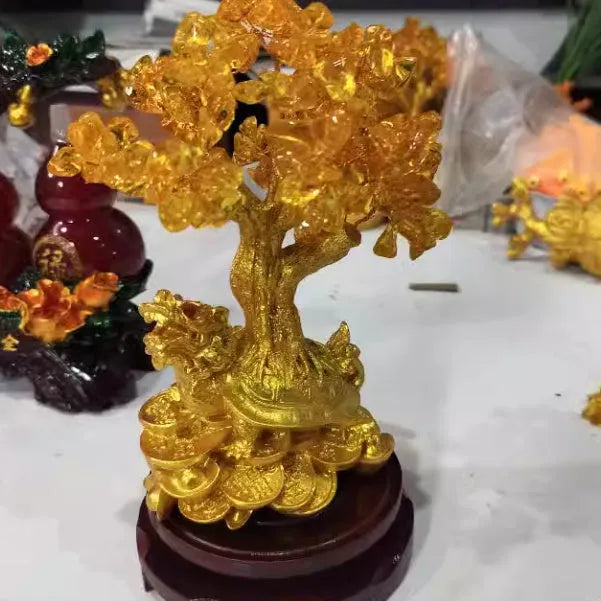 Citrine-coloured resin Feng Shui ornament of a small turtle on a money tree.