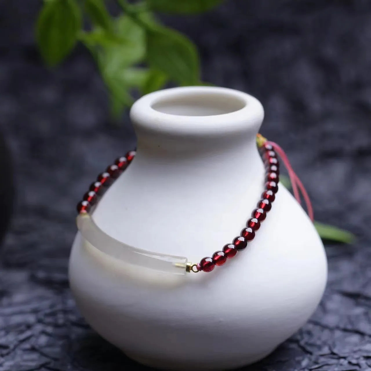 Adjustable red garnet and agate beaded bracelet with pull bead closure on wrist