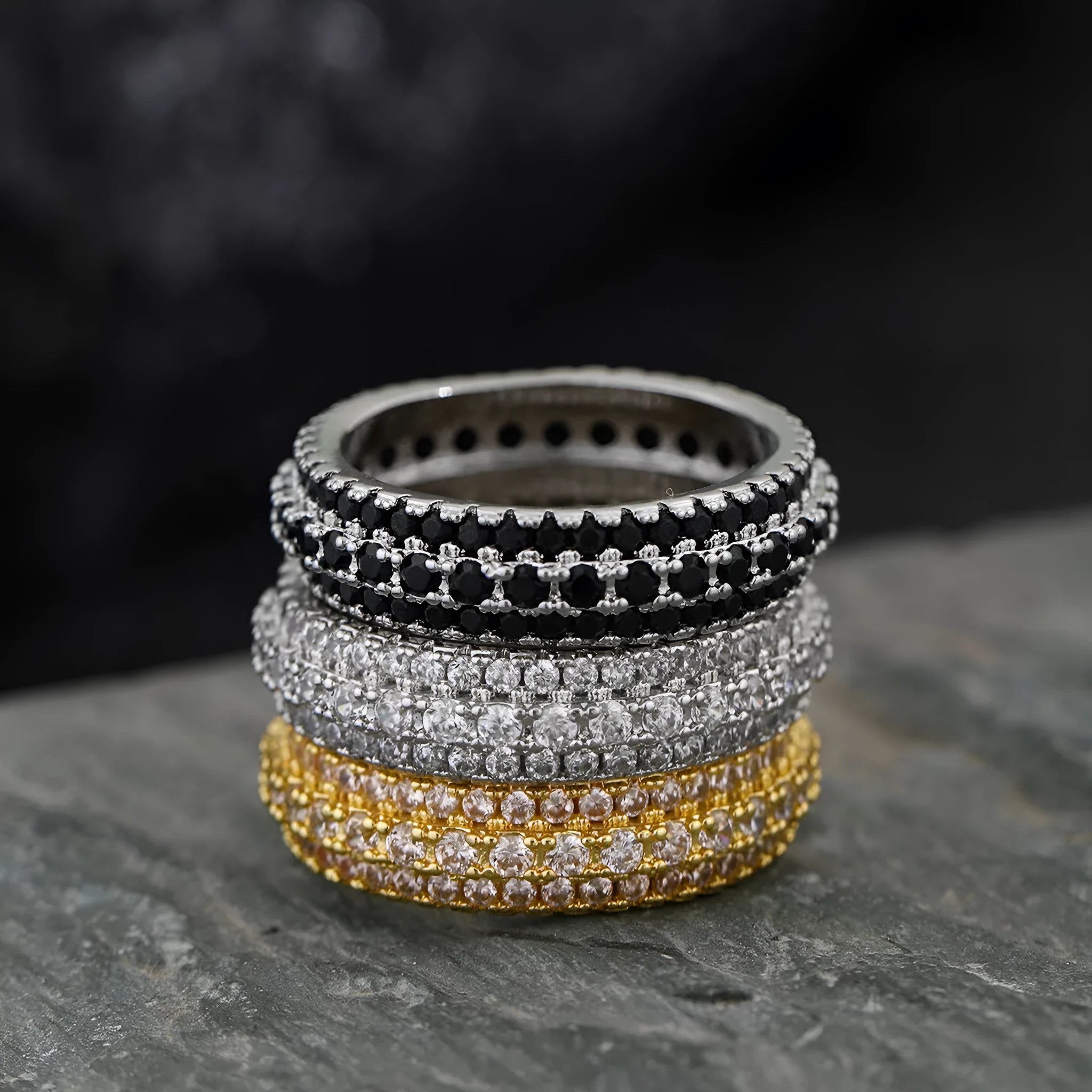 Geometric triangle-shaped copper ring with a zircon stone inlay, shown in different colour finishes.