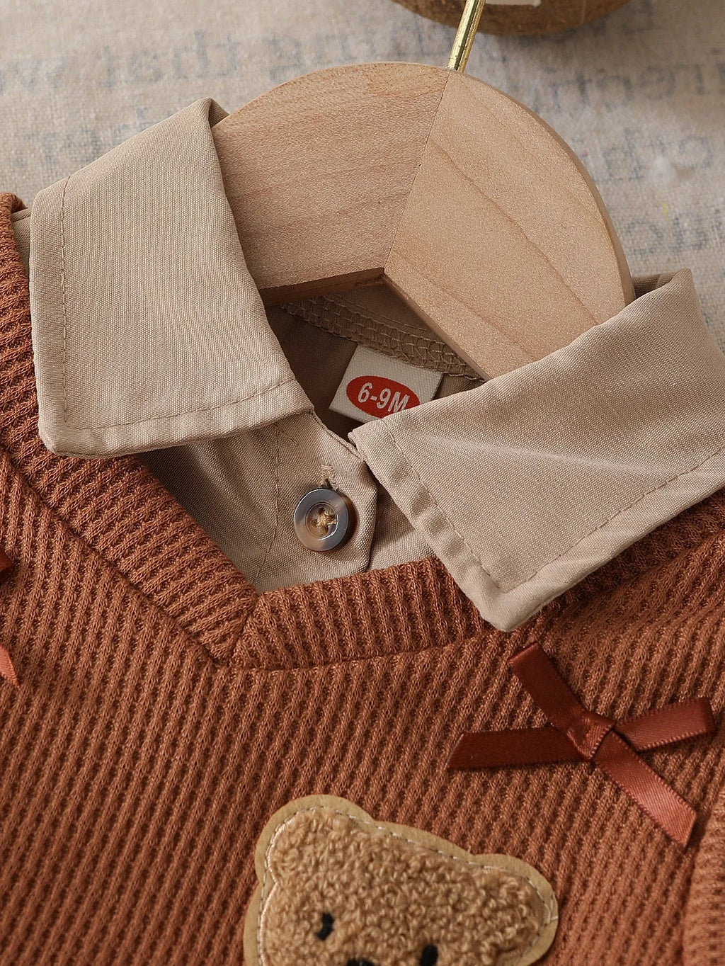 Girls' light brown plaid three-piece set with top, knitted vest, and pleated skirt on white background