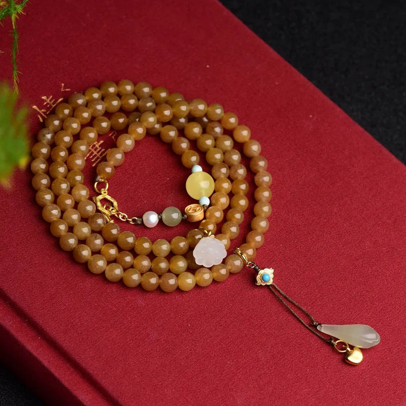 Women's jade bracelet with 6mm round beads in clear water green featuring leaf accents